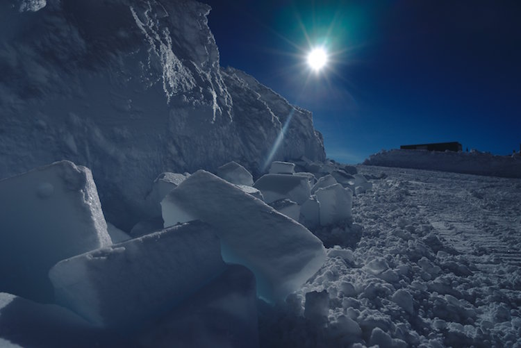 Bright sun, large chunks of ice in foreground.