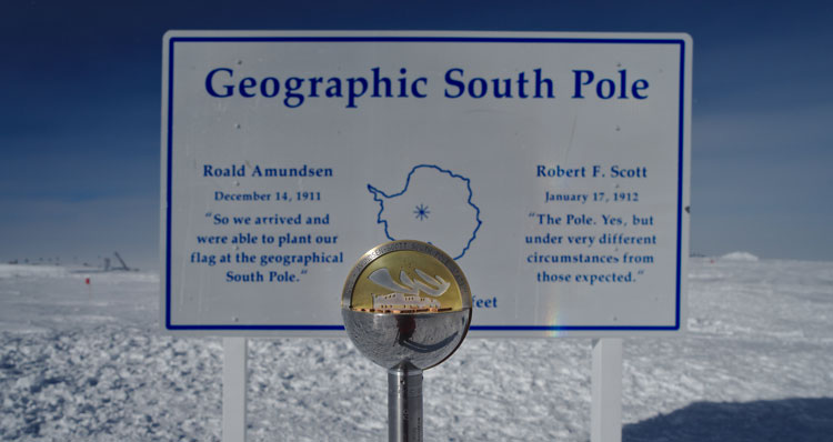 New pole marker in front of sign for geographic South Pole