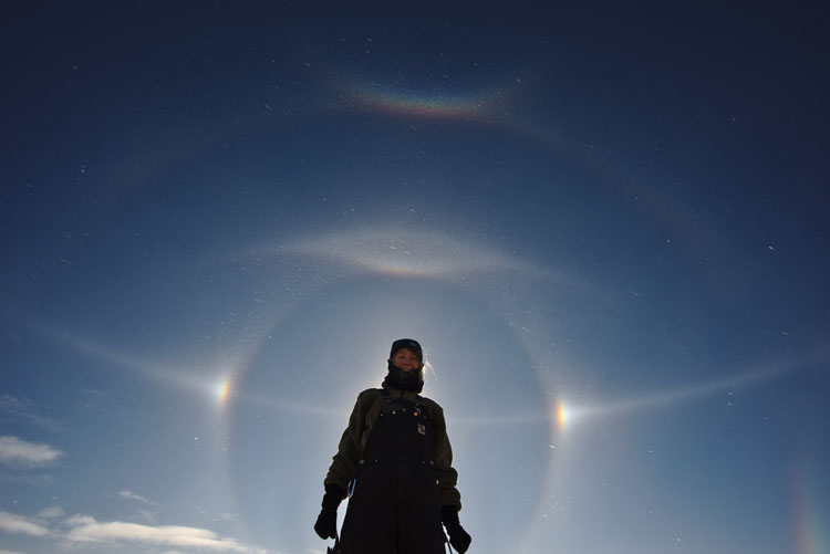 Person standing such that sun dogs halo their head