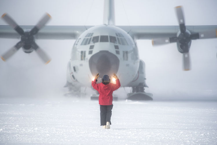 Person fin red parka from behind, parking a Herc.