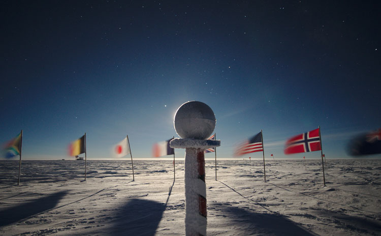 Frosty ceremonial pole marker with bright moon hidden behind the sphere.