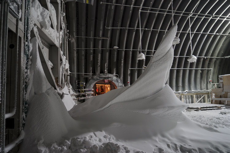 Huge snow drift, side view, inside a South Pole storage facility.