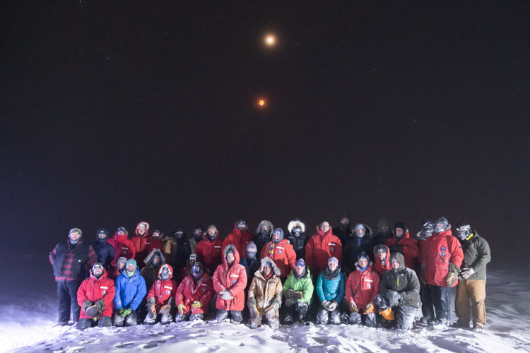 Group photo outside at South Pole, dark sky