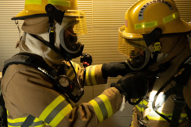 close-up of two firefighters in gear
