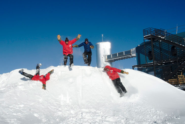 four people standing/playing on snowdrift