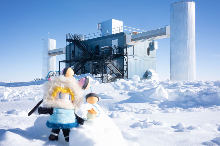 Small doll of Japanese cartoon character out on snow in front of IceCube Lab