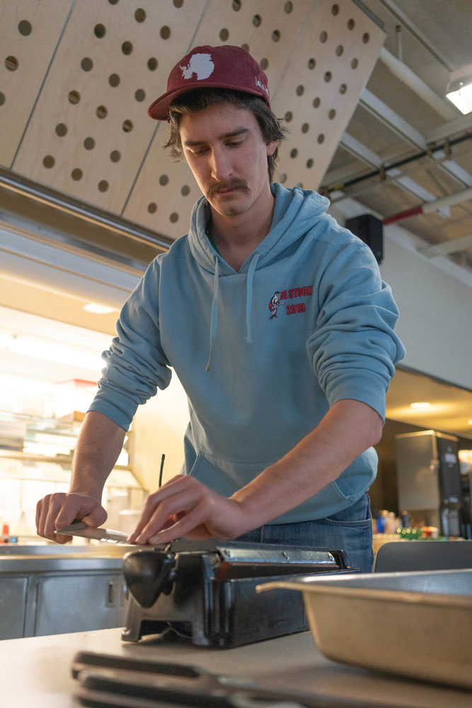 Person standing and sharpening a knife