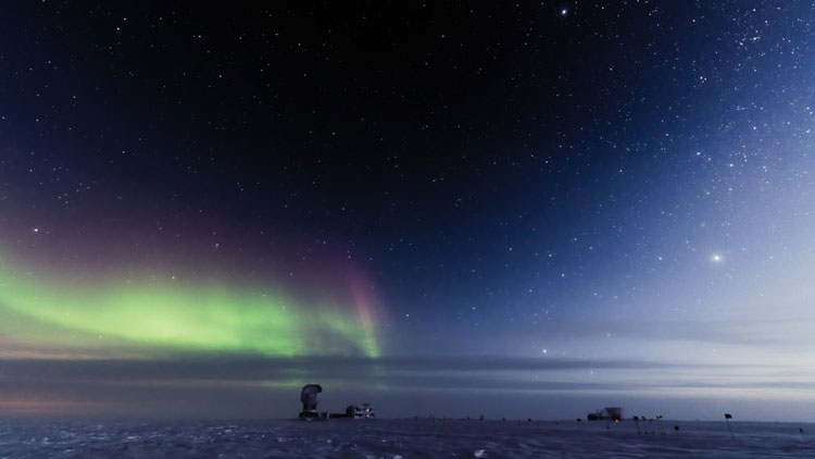 South Pole Telescope seen in distance along horizon at twilight