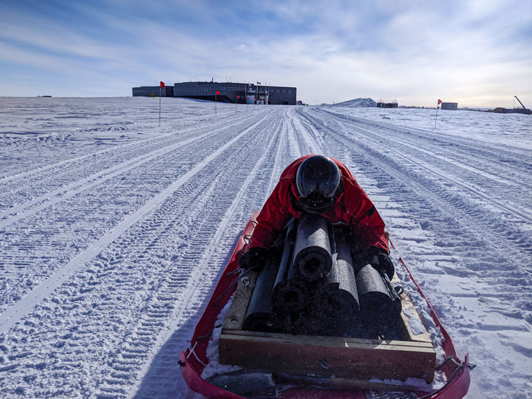 Person lying on top of cargo being hauled on a sled