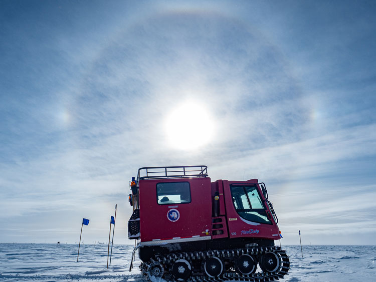 Sun halo in sky above snow vehicle