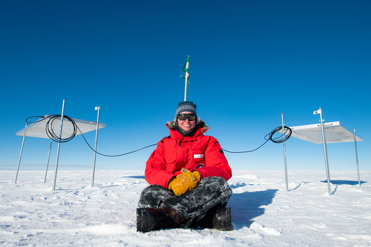 Person seated on ice between two scintillator panels