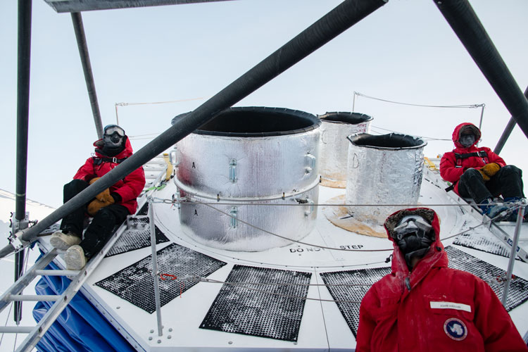 Several people in red parkas at South Pole's BICEP telescope