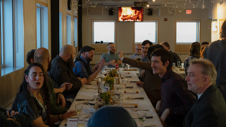 Long view of people at table for sunset dinner