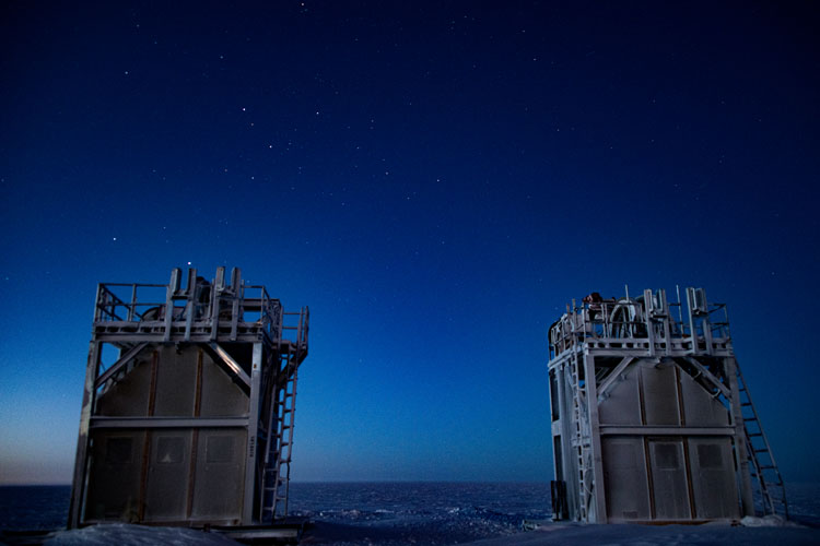 Two inactive drill towers with starry bluish sky behind