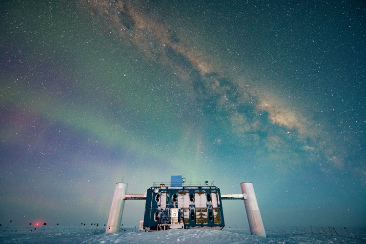 IceCube Lab with dark, bluish skies and stars and auroras