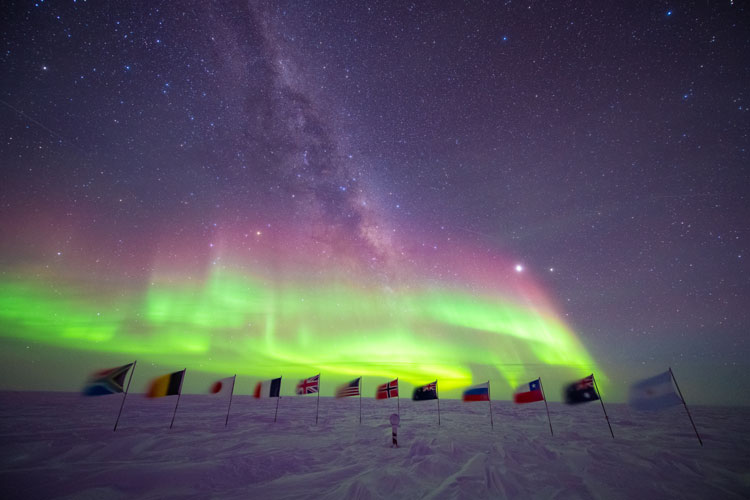 auroras above flags at ceremonial south pole