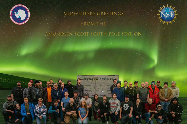 Midwinter greeting card, group photo below aurora at South Pole