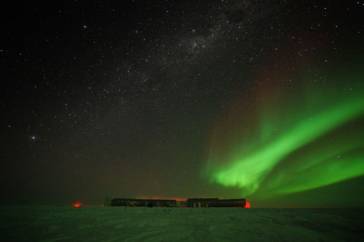 Streak of aurora over South Pole station in distance