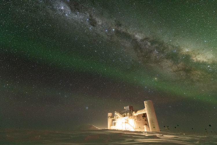 The IceCube Lab bathed in light, under starry skies