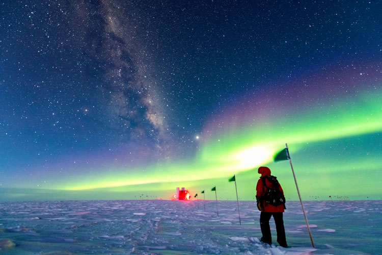 Person walking along flag line, under auroras