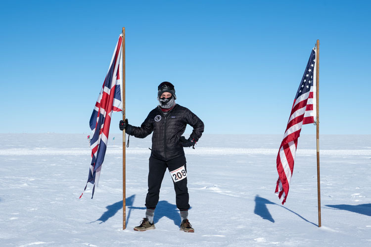 Person standing outside at South Pole holding the post of the British flag