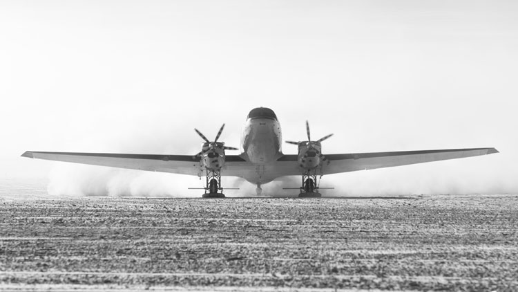 Black and white image showing head-on view of plane landing at South Pole.