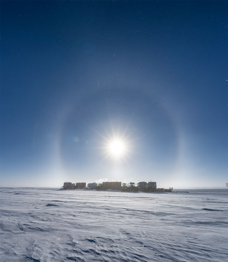 South Pole traverse seen in distance under a sun halo.