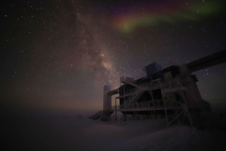 The IceCube Lab at night, with Milky Way and faint aurora overhead.