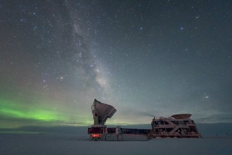 The South Pole Telescope with some auroras low in the sky and the Milky Way visible overhead.