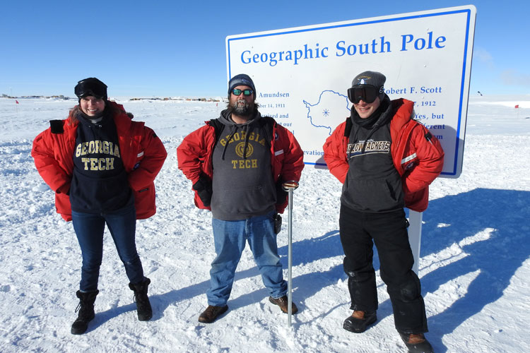 Three person photo opp in front of South Pole sign