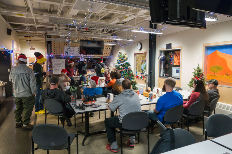 Group of people in midst of gift exchange in South Pole station galley 