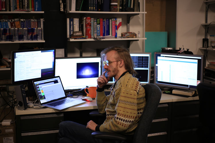 Winterover seated among computer monitors