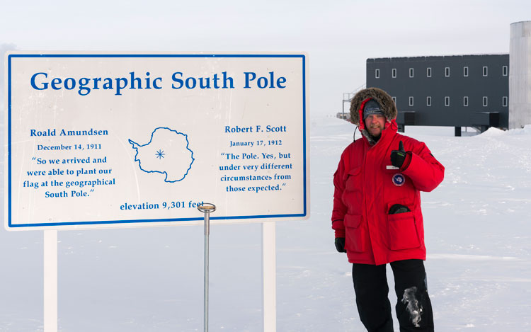 Martin standing next to sign and marker at geographic South Pole