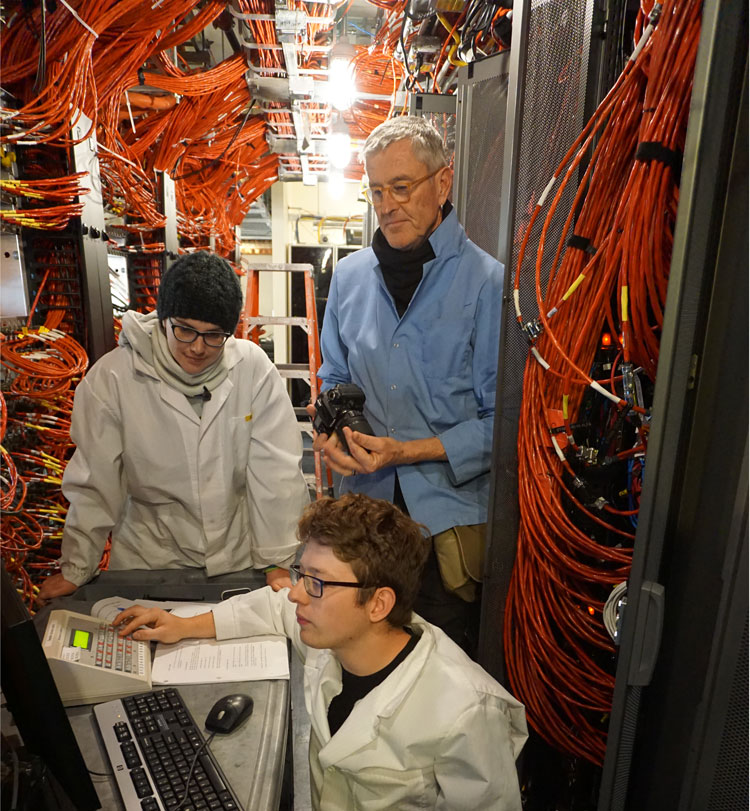 Group of people in IceCube Lab observing computer