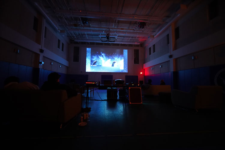 video projected on wall at end of dark gym