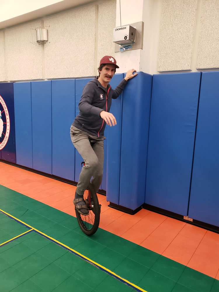 Man on unicycle in gym