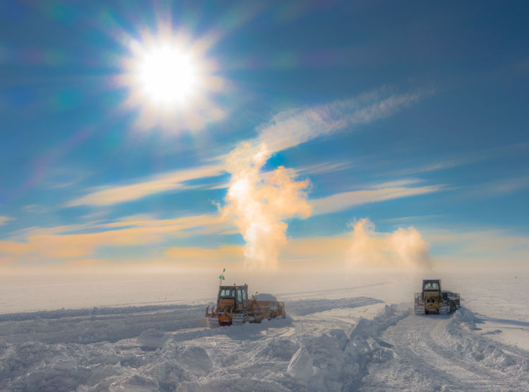 Two bulldozers moving snow