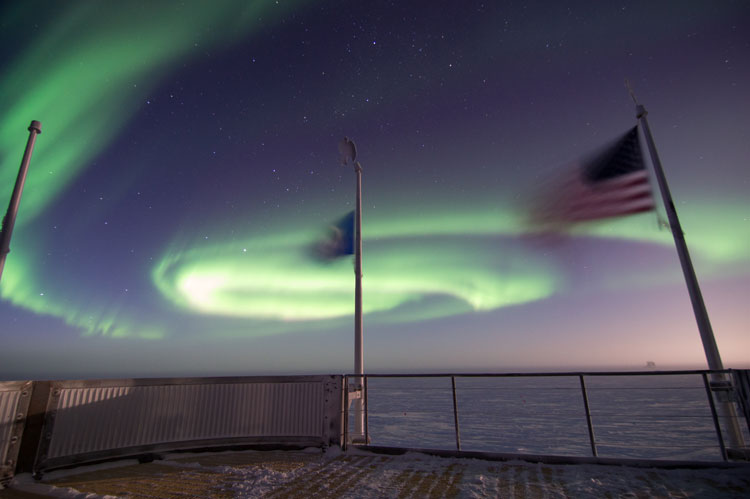 Flags flying with auroras in the background
