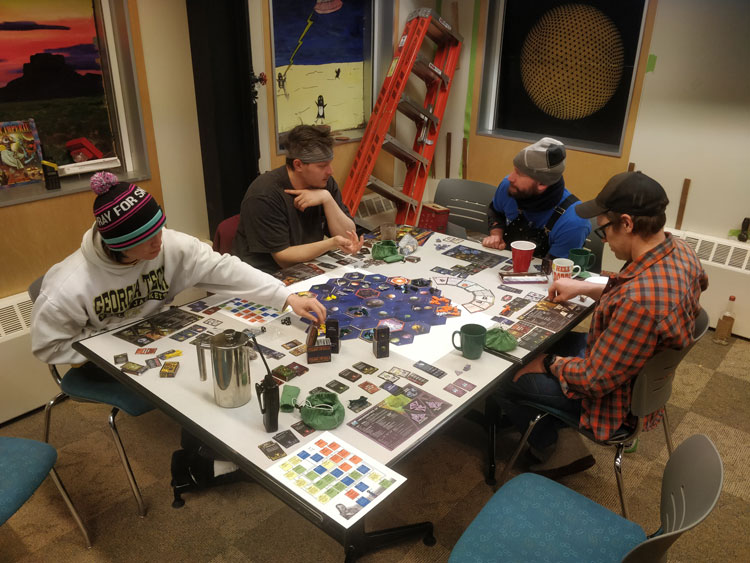 People sitting around a table playing a board game