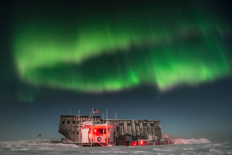 Green auroras appearing to hover in a circle above the south pole station