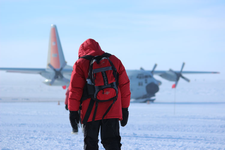 Winterover walking to the airplane to leave 