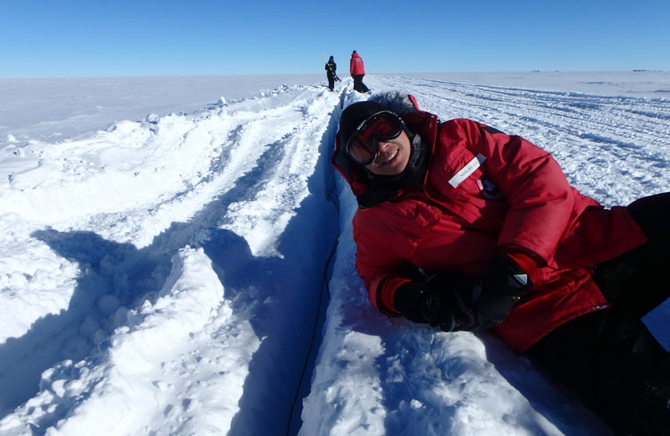 lounging on ice next to open trench at the South Pole
