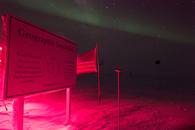 Catching a great photo of the Geographic South Pole point with auroras in the background. 