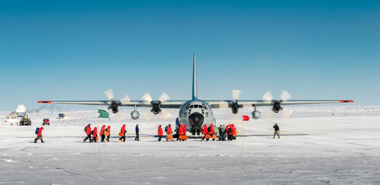 Group departing South Pole, walking in front of plane on ground