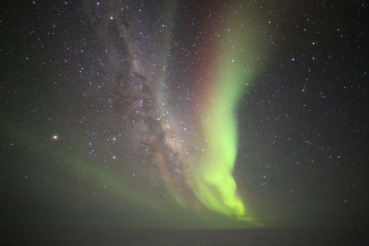 South Pole sky in winter with stars, Milky Way, and auroras
