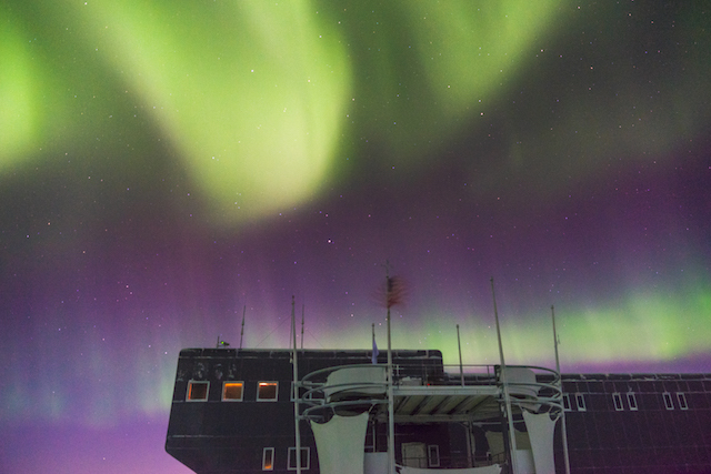 South Pole station under colorful sky of auroras