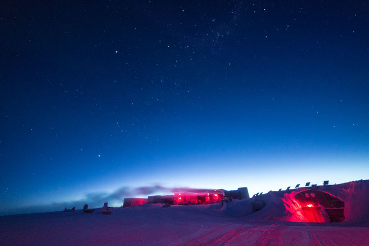 Light on horizon at South Pole with starry sky