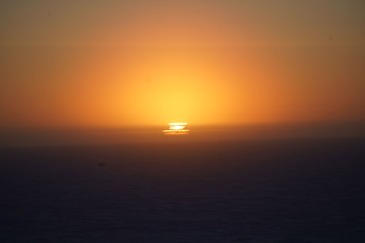 Orange sunset, with image of sun broken and refracted