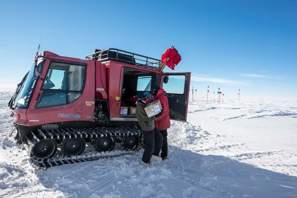 Unloading cargo from a large snowcat.