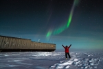 Aurora at South Pole, with person with arms in air